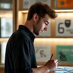 Portret van Koen Bakker, interieurontwerper gespecialiseerd in hout, bekijkt een moodboard.